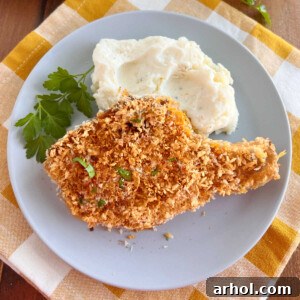 baked breaded pork chops with panko bread crumbs and mashed potatoes on plate