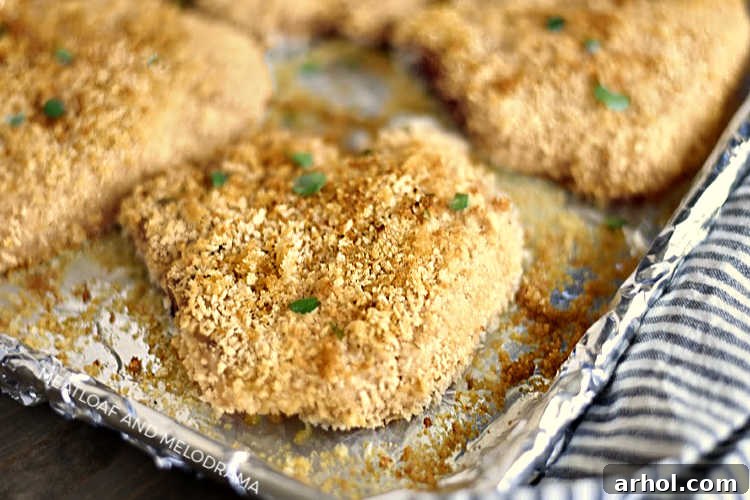 crispy baked breaded pork chops with panko on baking sheet