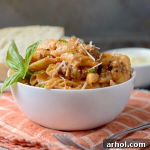 Instant Pot creamy sausage and shells pasta in a white serving bowl