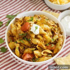 bowl of creamy instant pot taco pasta with sour cream and tomatoes