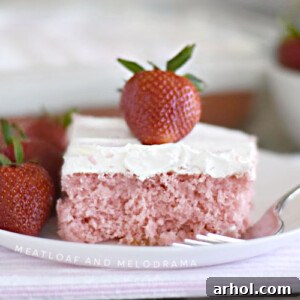 strawberry cream soda cake with whipped topping and strawberry on white plate