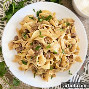Instant Pot Ground Beef Stroganoff with egg noodles, served on a white plate.