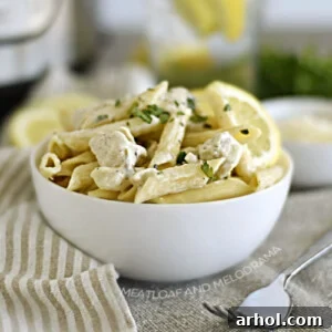 A bowl of Instant Pot Lemon Chicken Pasta, featuring tender chicken and penne pasta in a creamy lemon sauce.