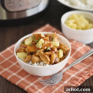 Instant Pot Hawaiian BBQ chicken served over rice in a bowl, garnished with pineapple chunks.