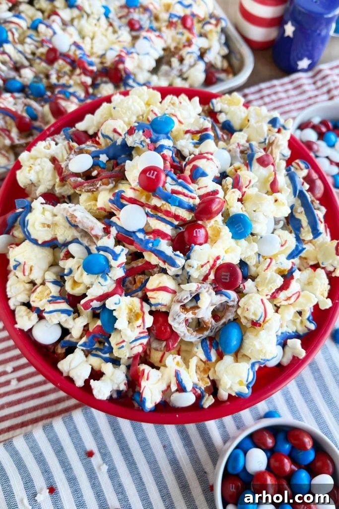 Stars and Stripes Popcorn Treat 2 Patriotic Popcorn with red, white, and blue candy and ribbons on a Fourth of July table, a perfect sweet and salty snack mix