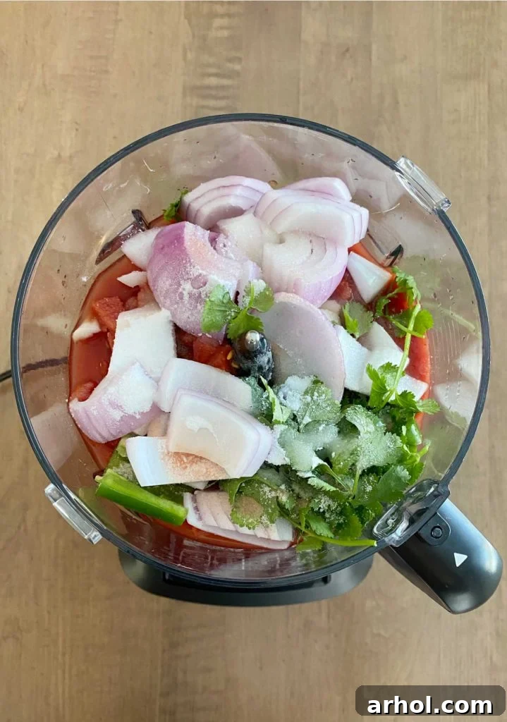 chop fresh ingredients and canned tomatoes for salsa in blender