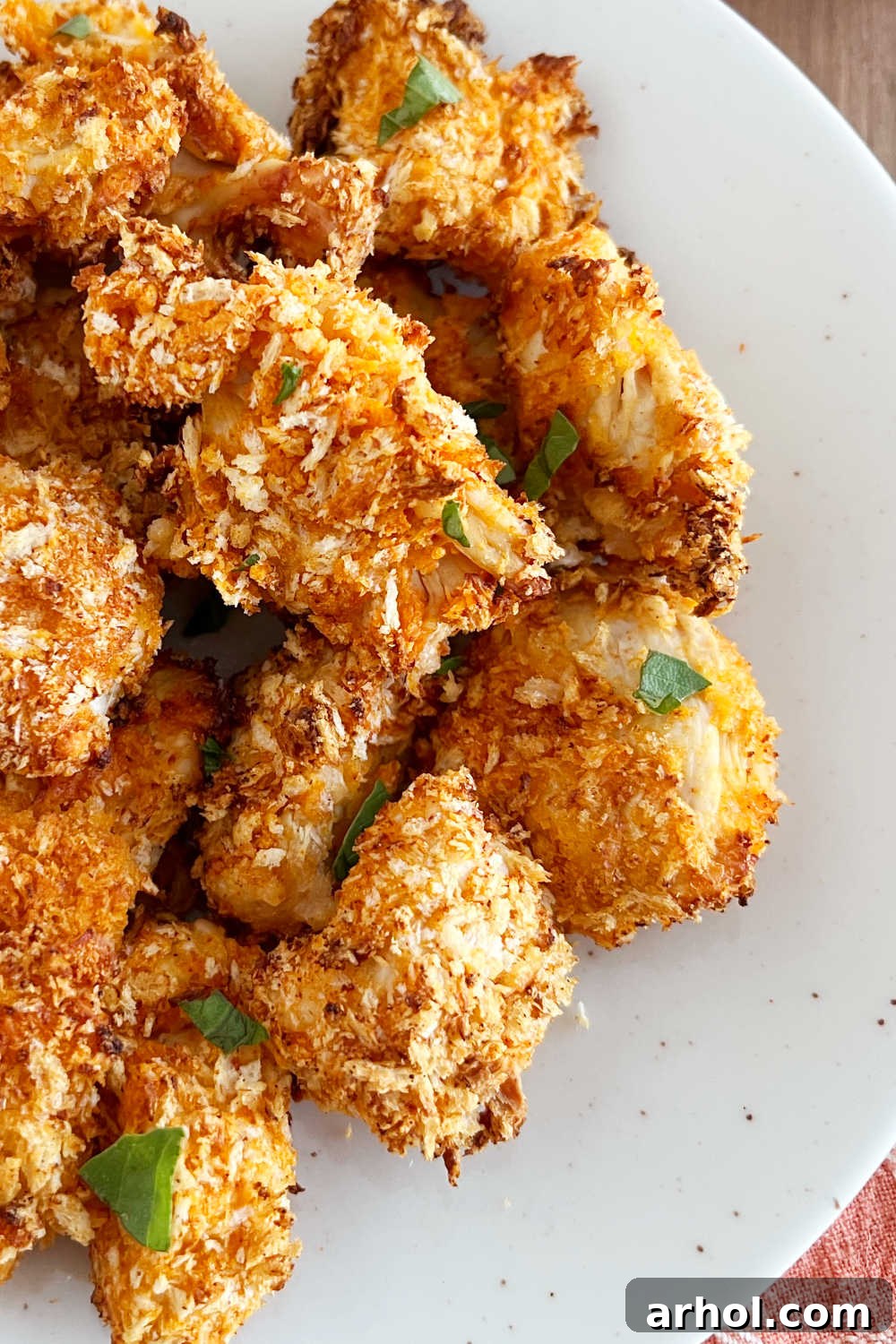 Crispy air fryer buffalo chicken nuggets stacked on a plate, ready for serving.