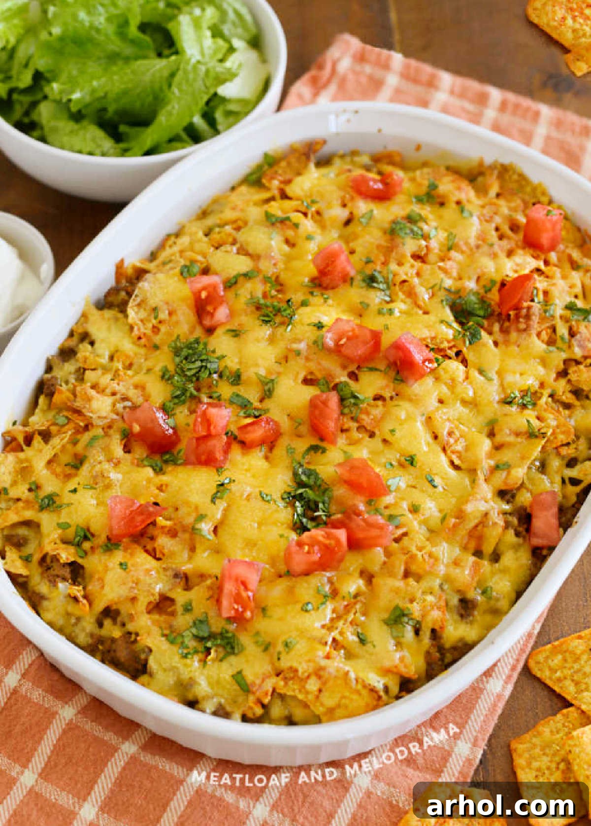 A vibrant Doritos casserole with ground beef, cheese, fresh tomatoes, and cilantro garnish, ready to serve.