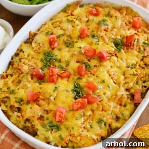 Close-up of a serving of Doritos casserole with ground beef and cheese, garnished with fresh cilantro.