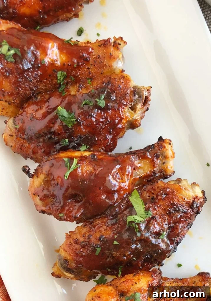 Crispy Air Fryer BBQ Chicken Wings with dry rub and BBQ sauce artfully arranged on a platter