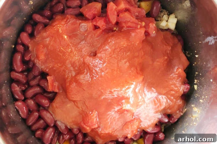 Chili ingredients are carefully layered, with the tomato sauce added last on top to prevent the burn notice during pressure cooking.