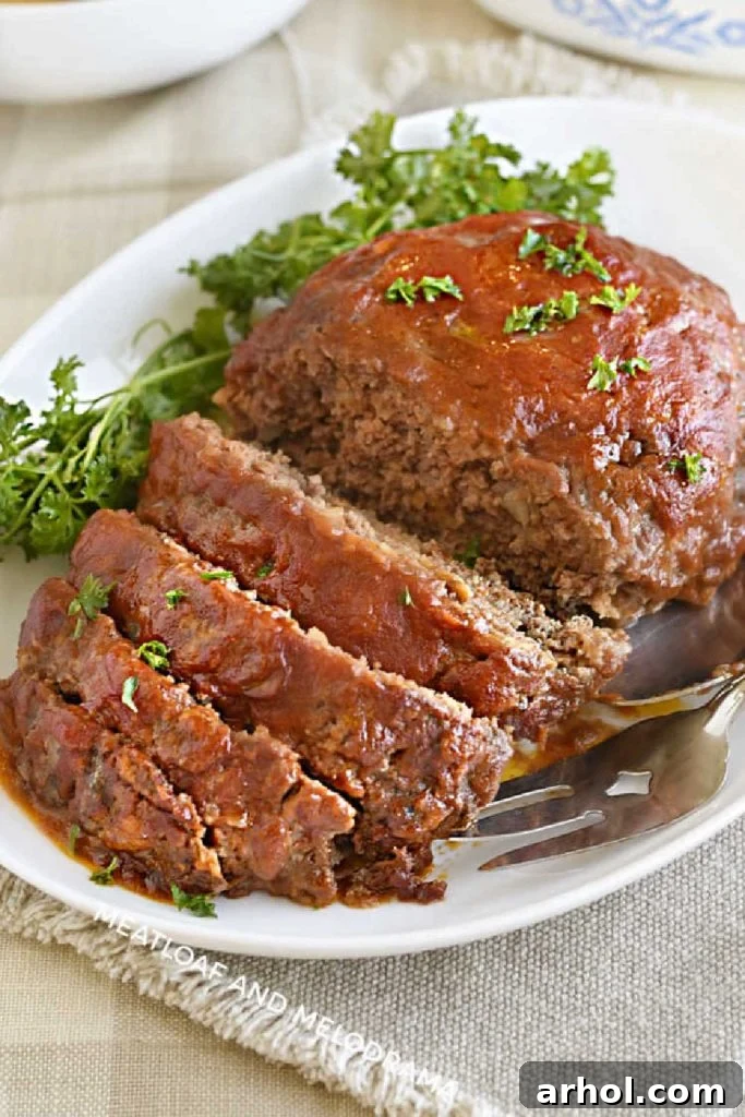 Juicy meatloaf with a glistening tomato sauce and brown sugar glaze, garnished with fresh parsley on a white platter, ready to be served as a comforting family dinner.