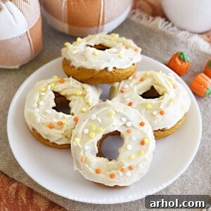 Pumpkin spice cake mix donuts with cream cheese frosting on platter, ready for serving