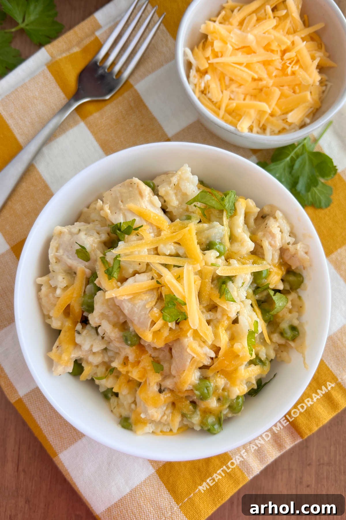 Dreamy Instant Pot Cheesy Chicken and Rice 2 Instant Pot Cheesy Chicken and Rice with peas and parsley, garnished and ready to serve on a rustic wooden table.