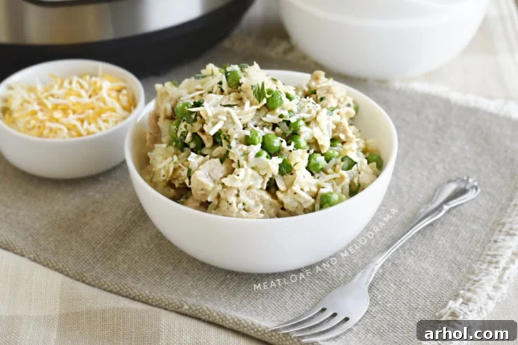 Dreamy Instant Pot Cheesy Chicken and Rice 10 A close-up shot of a bowl of creamy chicken and rice with peas, freshly made in the Instant Pot pressure cooker.