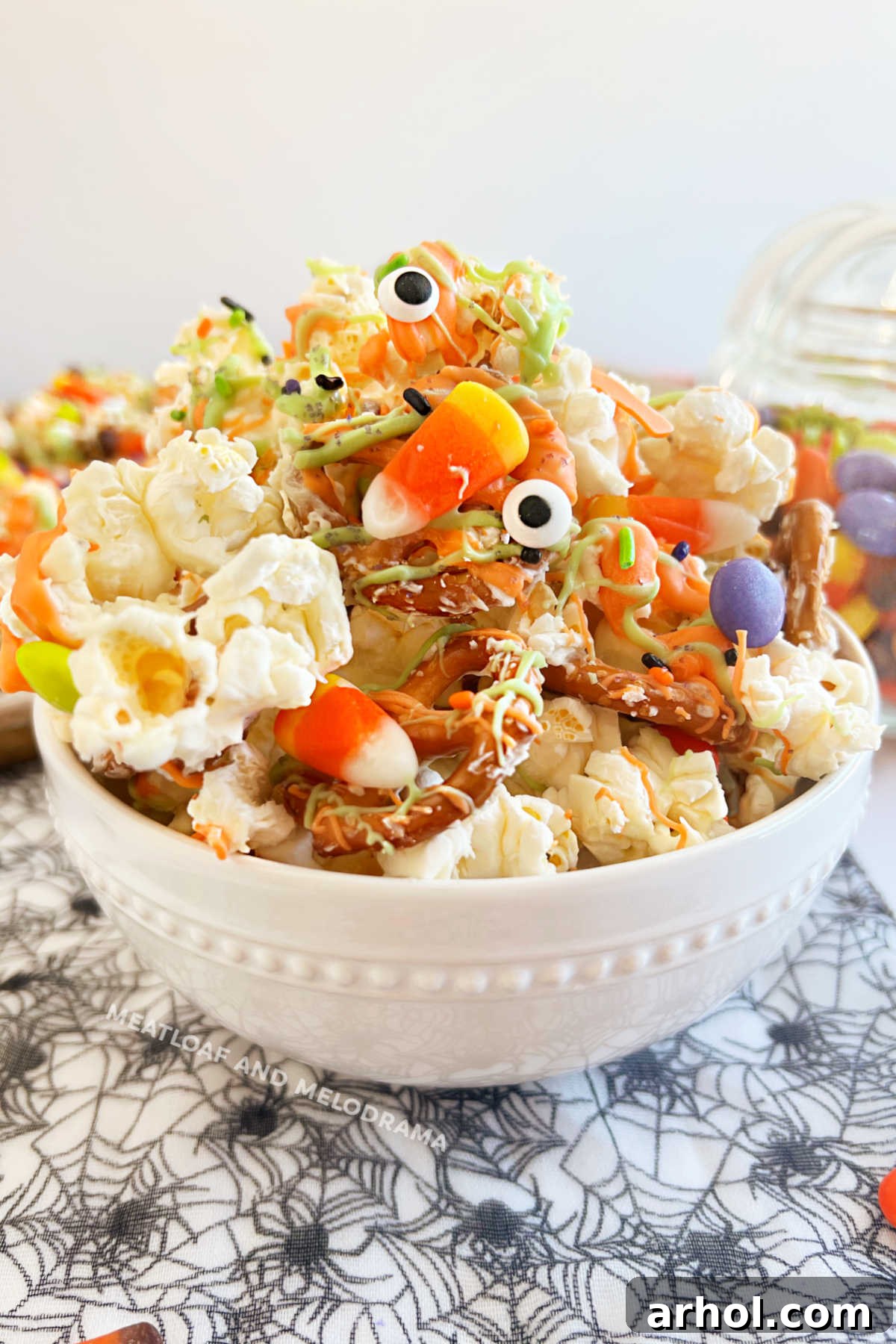 Monster Munch Halloween popcorn mix with pretzels and candy in a white bowl, ready to be enjoyed for Halloween