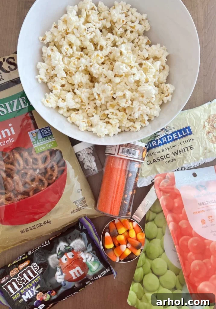 Popcorn, pretzels, white chocolate, candy, and candy melts laid out on a table, ready for Monster Munch preparation