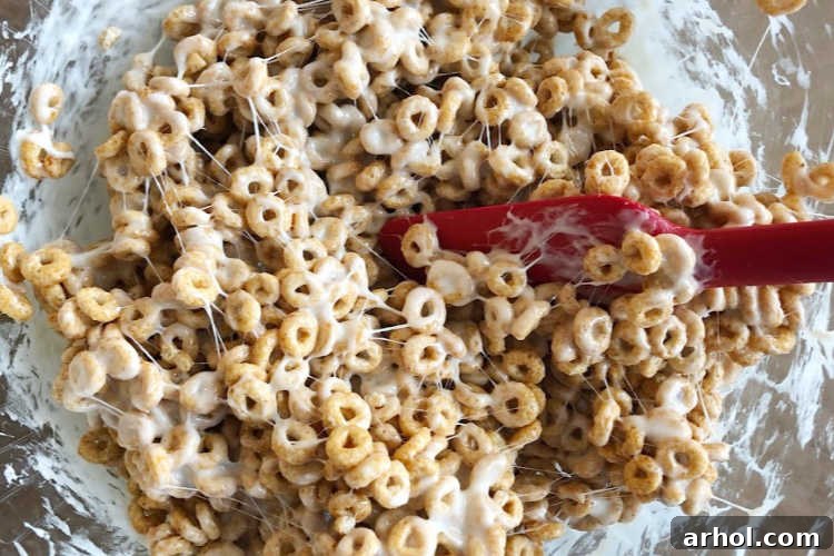 stir melted marshmallows and cheerios together in bowl