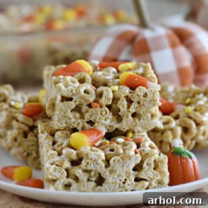 pumpkin spice cheerios treats with candy corn on a white plate with pumpkins