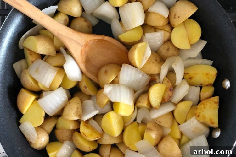 fry cut baby potatoes and onions in skillet