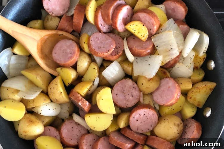 cook kielbasa slices with onions and potatoes in skillet
