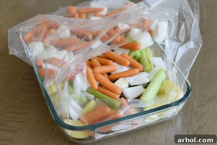 All ingredients, including chuck roast, baby carrots, celery, potatoes, and onions, are now placed inside the oven bag.
