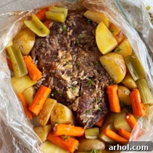 A savory beef pot roast cooked in an oven bag, seasoned with onion soup mix, and surrounded by tender carrots, potatoes, and celery, ready to be served.