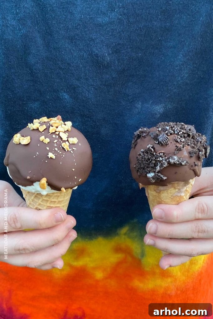 girl holding ice cream drumsticks in each hand, happily presenting the homemade treats