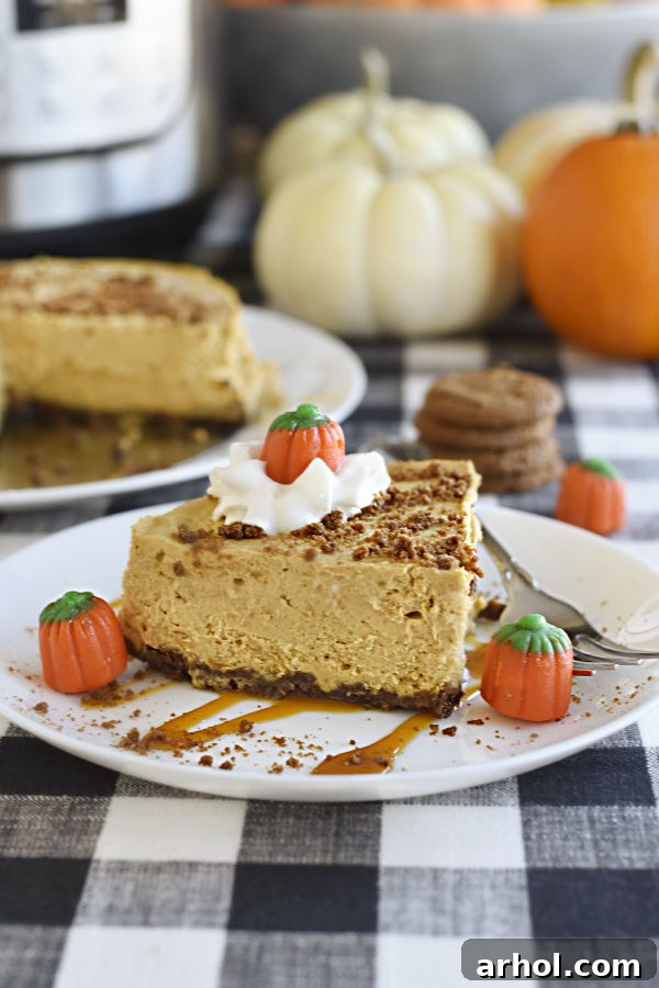 Velvety Instant Pot Pumpkin Cheesecake 7 Beautifully plated Instant Pot Pumpkin Cheesecake with gingersnap crust, drizzled with caramel, topped with whipped cream, and garnished with candy pumpkins, ready to be enjoyed.