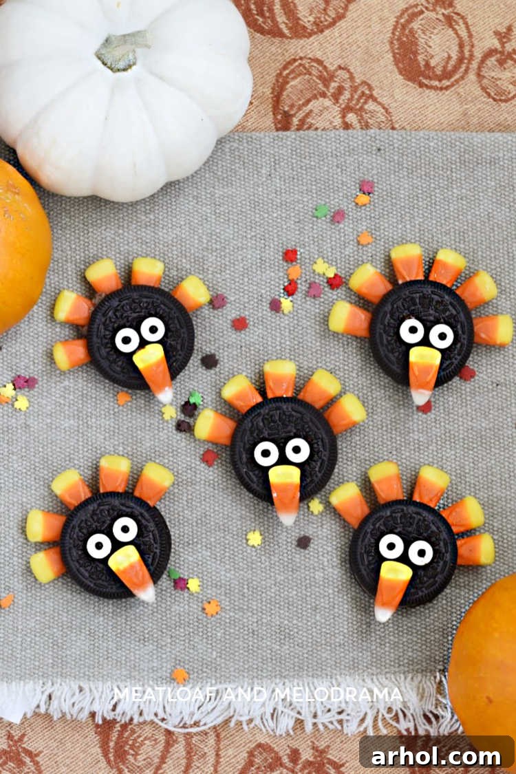 Finished Oreo turkeys made from Oreo cookies and candy corn, displayed on a festive Thanksgiving tablecloth with pumpkins, ready to be enjoyed.
