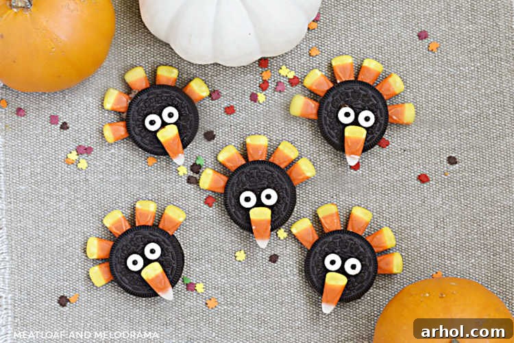 A festive display of finished turkey cookies, crafted from Oreos, candy corn, and candy eyes, arranged on a brown placemat with decorative pumpkins, evoking the spirit of Thanksgiving.
