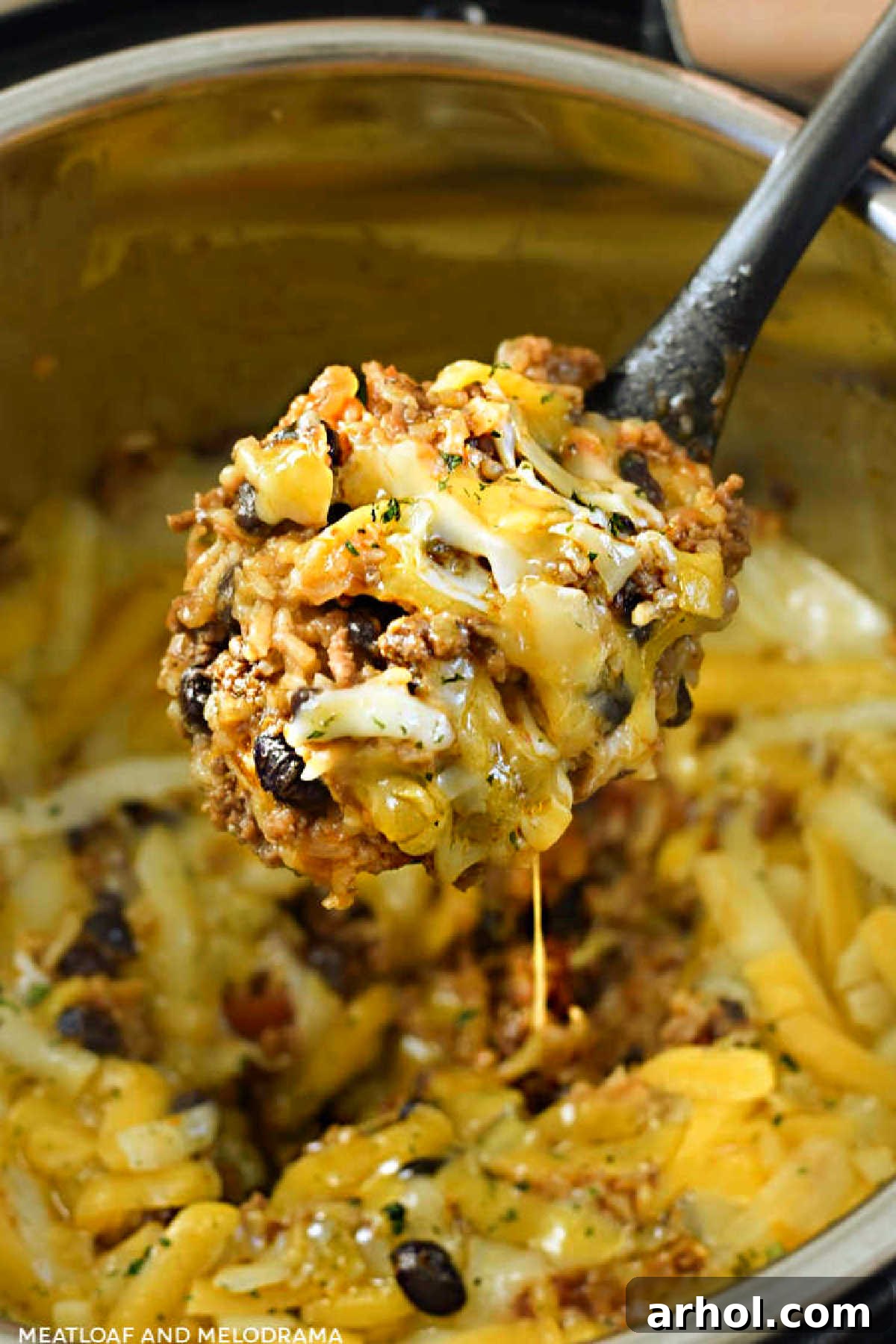 Instant Pot Mexican beef and rice with cheese on serving spoon