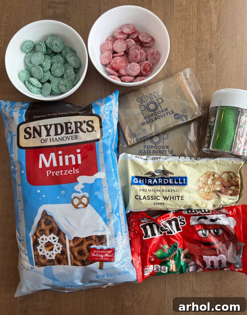 A vibrant flat lay showcasing the key ingredients for Christmas Crunch: colorful candy melts, crisp pretzels, fluffy popcorn, luscious white chocolate chips, festive M&M candies, and a variety of sprinkles, all ready for mixing.