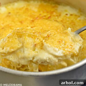 Instant Pot Potatoes Au Gratin on a serving spoon, showing the golden cheese topping.