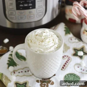 Cup of hot chocolate with whipped cream in front of an Instant Pot, beautifully styled for a recipe card.
