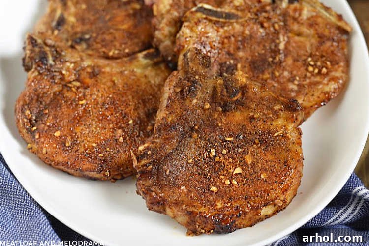 Close-up of dry-rubbed, bone-in air fryer pork chops arranged beautifully on a serving platter, ready to be served.