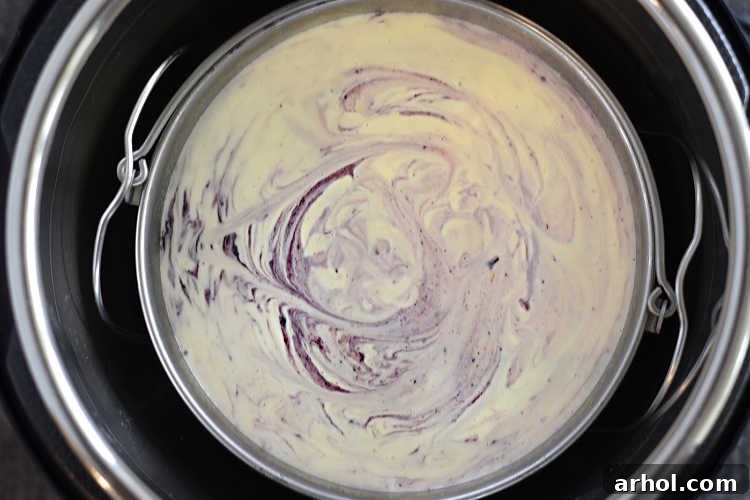 The lemon blueberry swirl cheesecake nestled inside the Instant Pot pressure cooker after cooking, perfectly steamed.