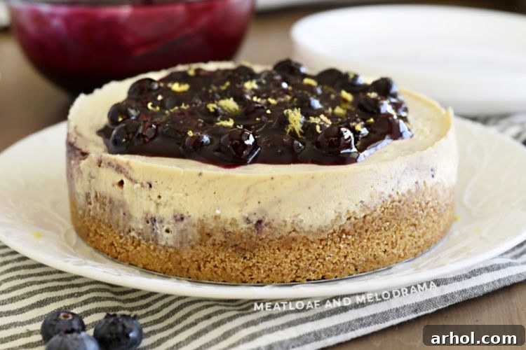 A stunning lemon cheesecake topped with homemade blueberry sauce and delicate lemon zest, presented on a elegant platter.