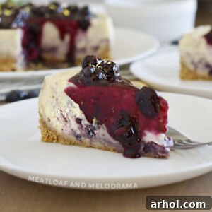 A mouth-watering slice of Instant Pot Lemon Blueberry Cheesecake with blueberry sauce on top and sides.