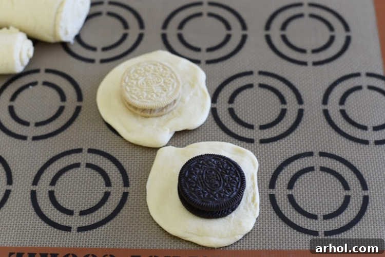 Assortment of chocolate and lemon Oreo cookies meticulously placed on individual circles of crescent roll dough, perfectly poised for wrapping.