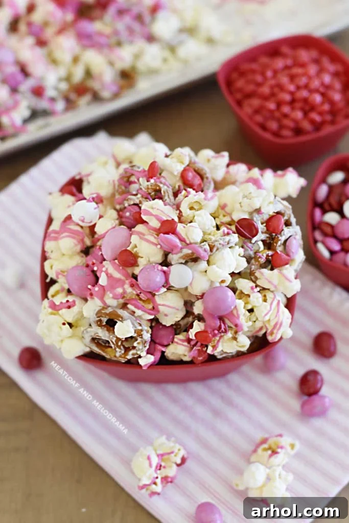 Sweetheart Snack Medley 7 A vibrant bowl of Valentine's Day popcorn snack mix, showcasing red and pink candies, ready to be served and enjoyed.