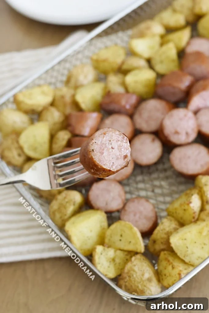 A single slice of perfectly air-fried smoked sausage on a fork, highlighting its inviting texture and golden-brown exterior.