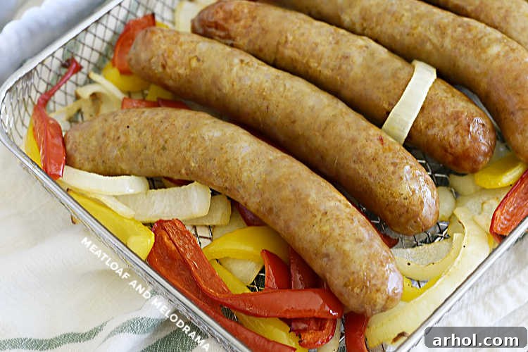 Italian sausages cooked with red and yellow bell peppers and onions in air fryer oven tray