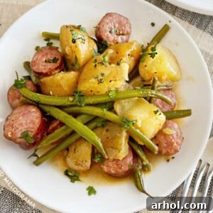 Kielbasa sausage with baby potatoes and green beans on a white plate