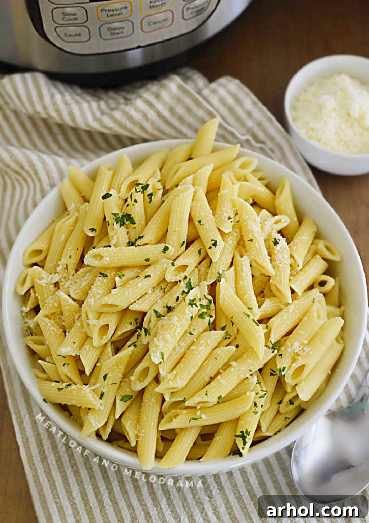 A comforting bowl of perfectly cooked penne pasta with a sprinkle of Parmesan, freshly made in an Instant Pot pressure cooker.