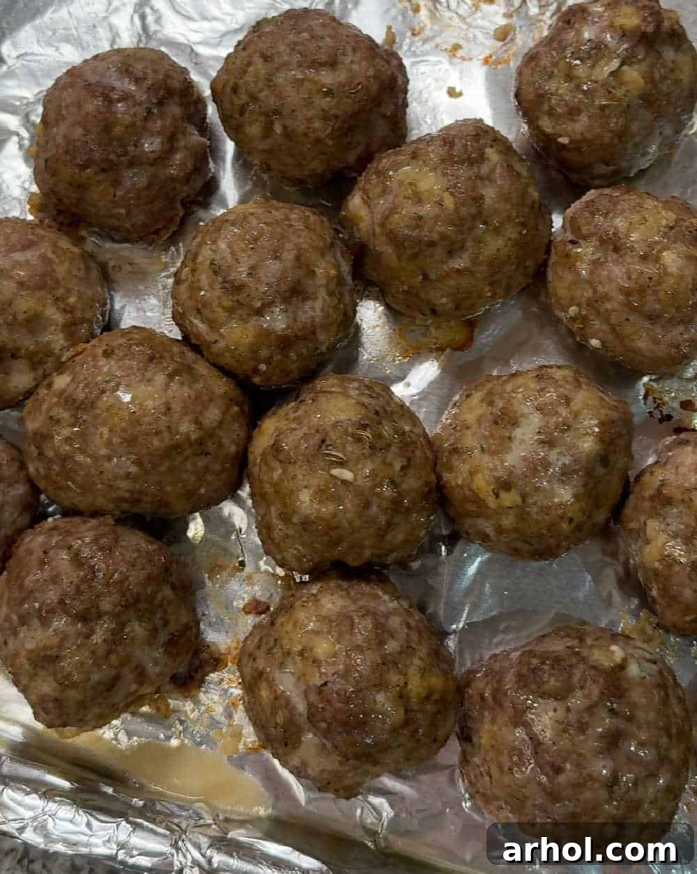Step 4: Perfectly baked and lightly browned meatballs on a sheet pan, fresh out of the oven.