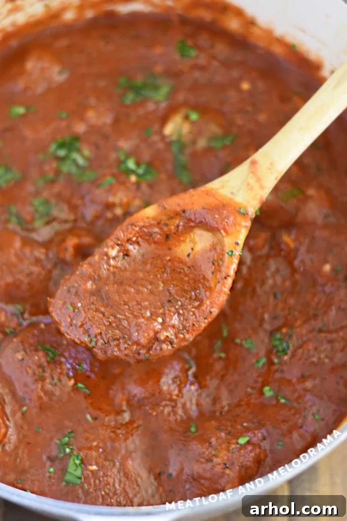 Homemade spaghetti sauce garnished with fresh parsley in a large pot, ready to be served over pasta.