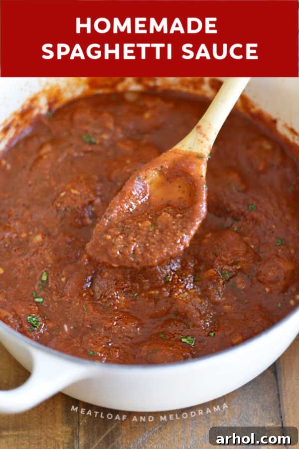 Close-up of thick, rustic homemade spaghetti sauce in a white Dutch oven, showcasing its rich texture.