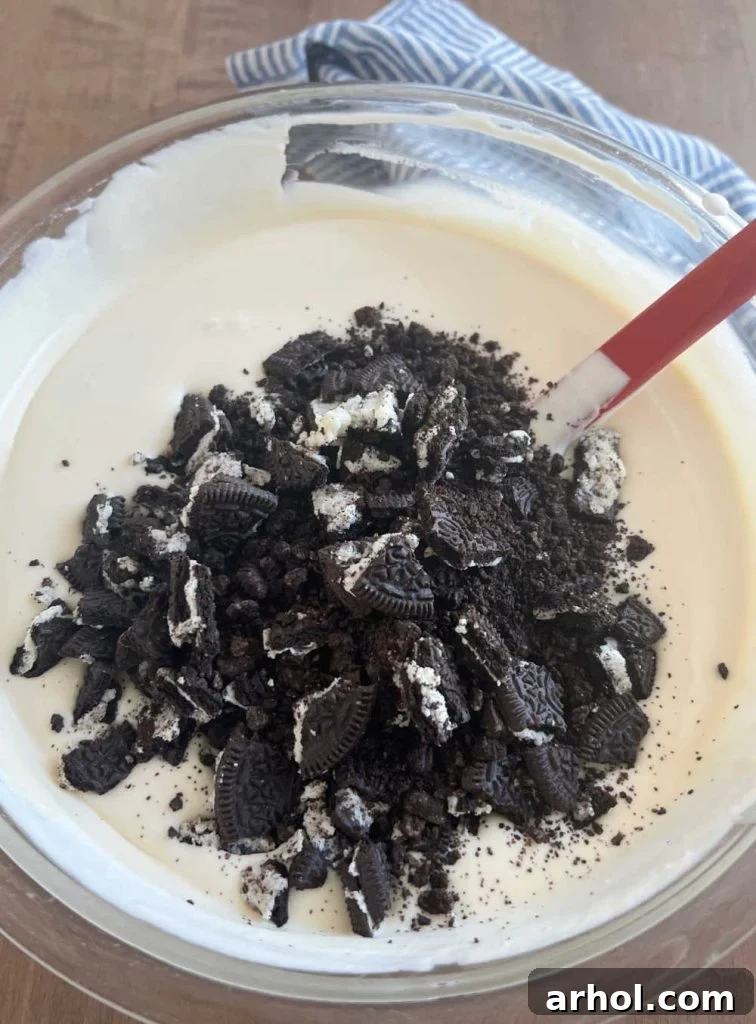 Crushed Oreo cookies mixed into the creamy milk base, ready for freezing.