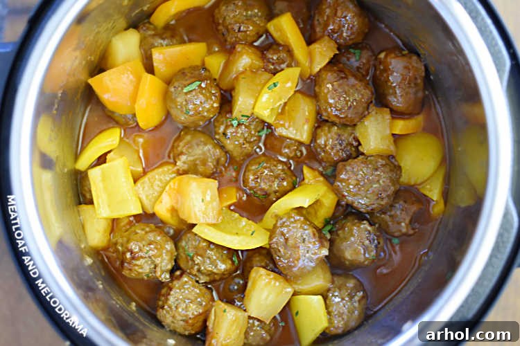 Sweet and sour meatballs with pineapple and bell peppers simmering in the pressure cooker.
